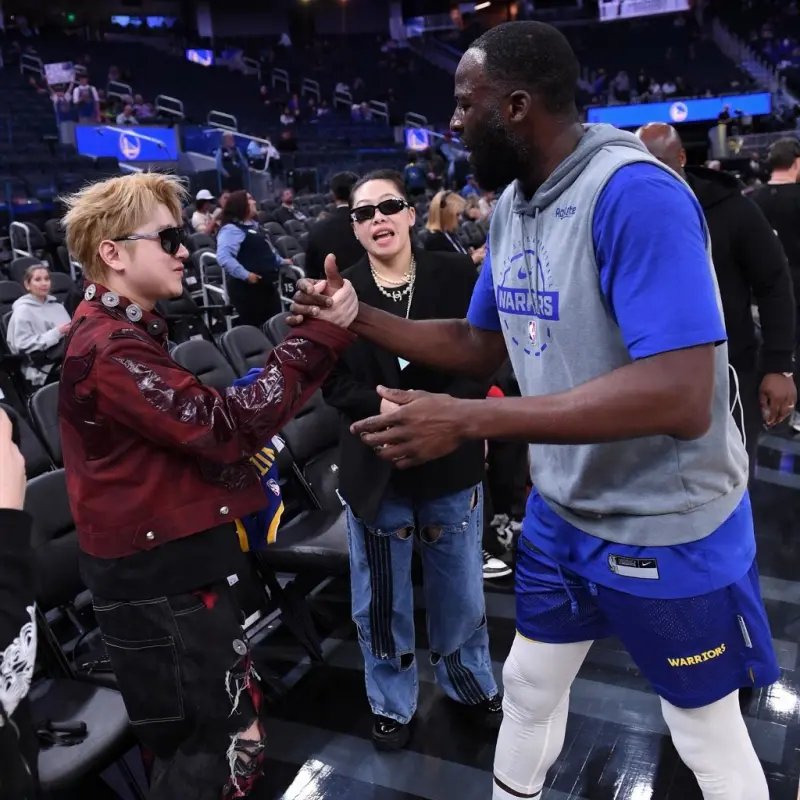 aoke-格林与王以太握手致意，并在后者的专属球衣上留下签名